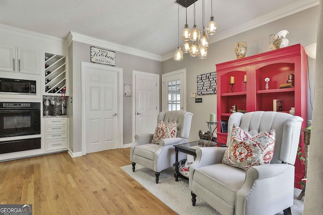 living area featuring a notable chandelier, crown molding, a textured ceiling, and light wood-type flooring