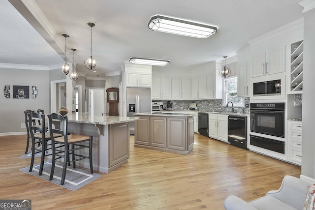 kitchen featuring a kitchen island, built in microwave, a sink, stainless steel refrigerator with ice dispenser, and dishwasher