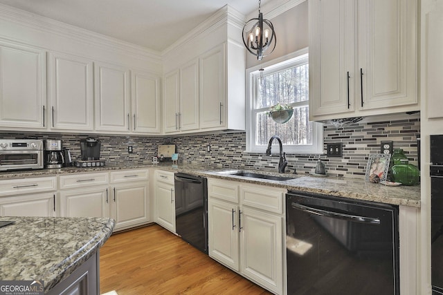 kitchen with decorative backsplash, light wood-style flooring, dishwasher, and a sink