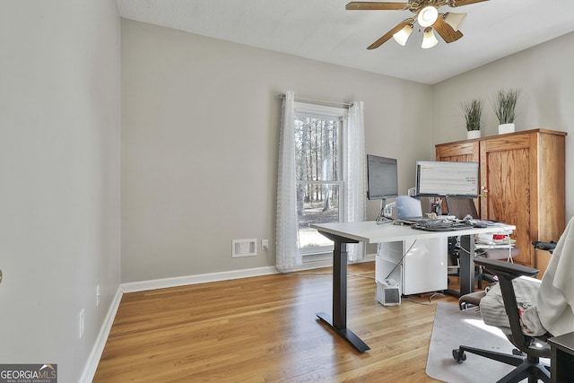 office with visible vents, baseboards, a ceiling fan, and light wood finished floors