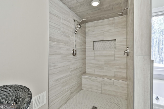 full bath featuring visible vents and a tile shower