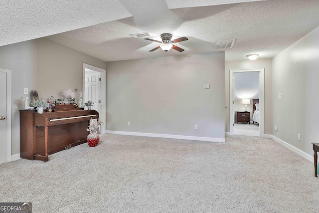 interior space featuring visible vents, ceiling fan, and carpet flooring