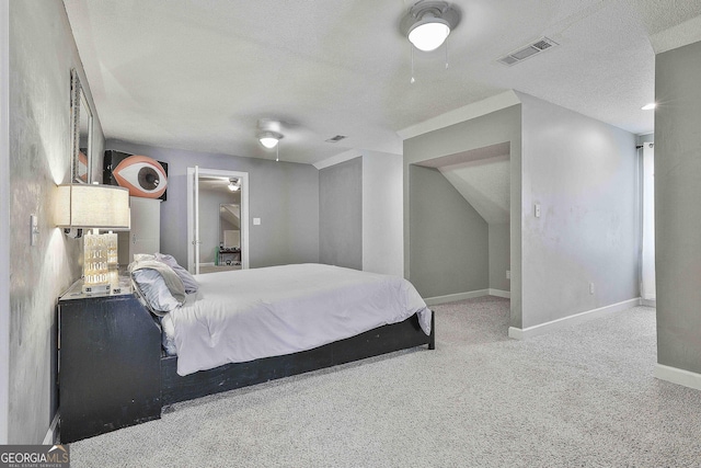 bedroom featuring a ceiling fan, carpet, visible vents, baseboards, and a textured ceiling