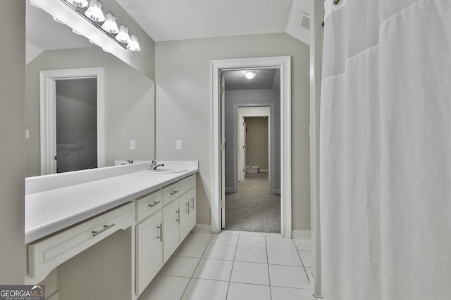 full bath with tile patterned floors, visible vents, a textured ceiling, lofted ceiling, and vanity