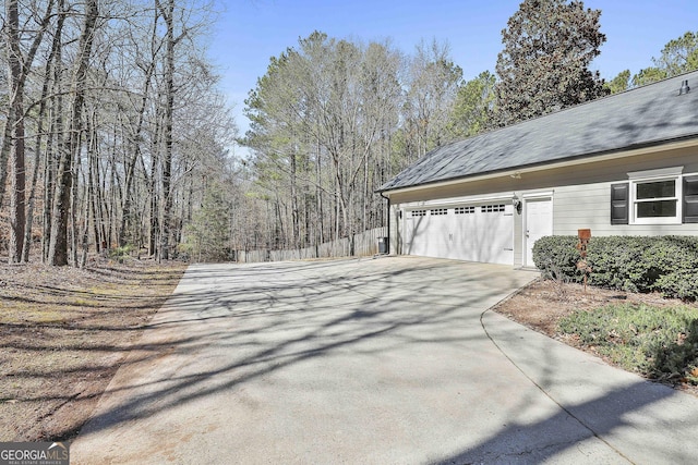 view of property exterior featuring a garage and concrete driveway