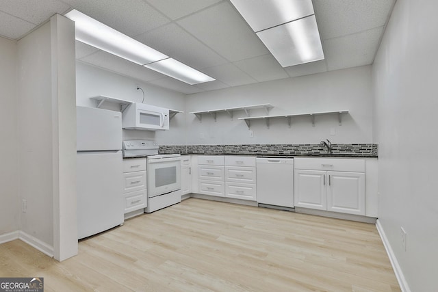 kitchen featuring white appliances, light wood finished floors, open shelves, white cabinets, and dark countertops