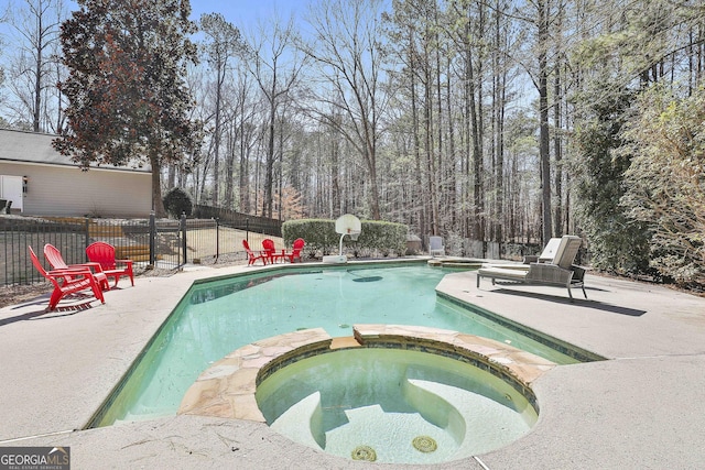 view of swimming pool featuring a pool with connected hot tub, a fenced backyard, and a patio area