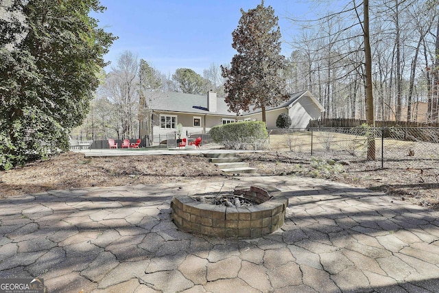 back of house with a patio area, fence, a chimney, and an outdoor fire pit