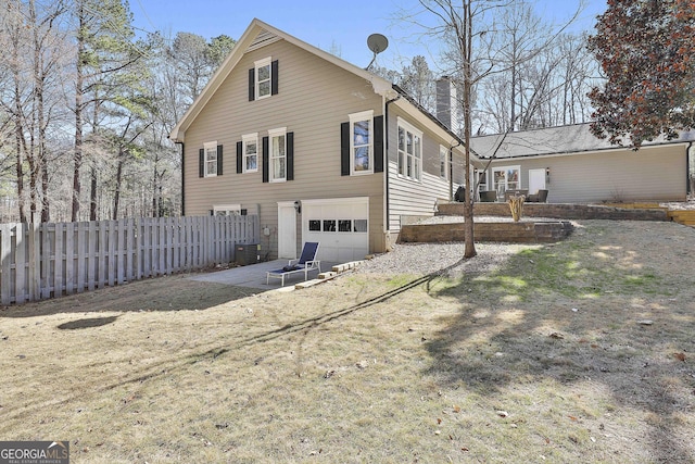 exterior space with cooling unit, a chimney, an attached garage, and fence