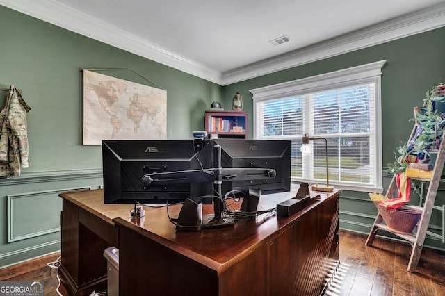 office area featuring visible vents, crown molding, dark wood-type flooring, a wainscoted wall, and a decorative wall