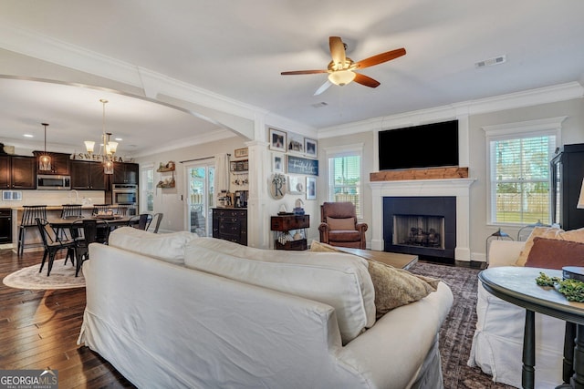 living room featuring arched walkways, a fireplace, dark wood-style flooring, and crown molding