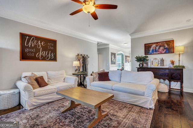 living area featuring baseboards, ornamental molding, hardwood / wood-style flooring, arched walkways, and a ceiling fan