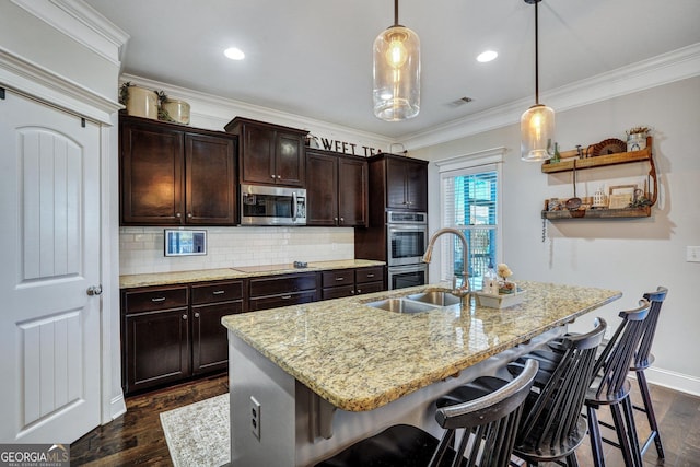 kitchen with dark wood-style floors, a breakfast bar, a sink, ornamental molding, and appliances with stainless steel finishes