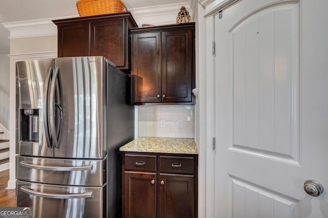 kitchen featuring dark brown cabinetry, backsplash, crown molding, and stainless steel refrigerator with ice dispenser