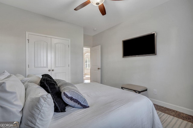 bedroom with a closet, ceiling fan, baseboards, and carpet floors