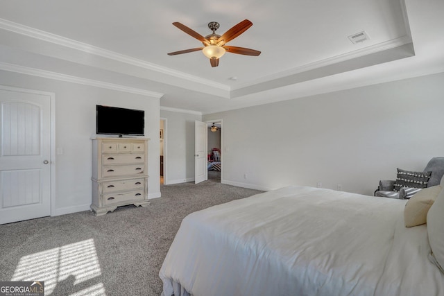 carpeted bedroom with a ceiling fan, baseboards, visible vents, a tray ceiling, and ornamental molding