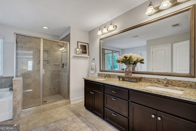 full bathroom with double vanity, visible vents, a shower stall, and a sink