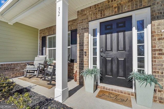 property entrance with brick siding and covered porch