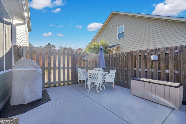 view of patio with outdoor dining area, grilling area, and fence