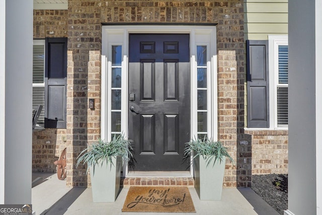 entrance to property featuring brick siding