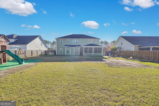 rear view of house with a yard, a fenced backyard, a sunroom, a playground, and a residential view