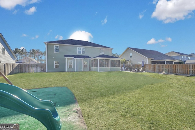 back of house with a yard, a fenced backyard, and a sunroom