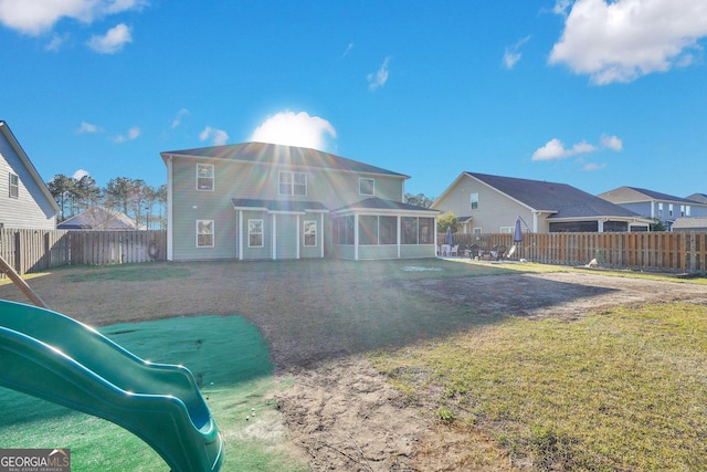 back of house with a lawn, a fenced backyard, and a sunroom