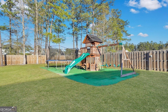 communal playground featuring a yard, a trampoline, and a fenced backyard