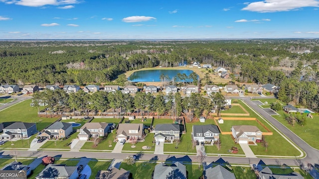 drone / aerial view featuring a residential view, a water view, and a view of trees