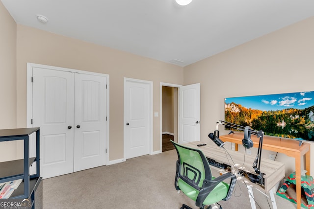 office area featuring baseboards and light carpet