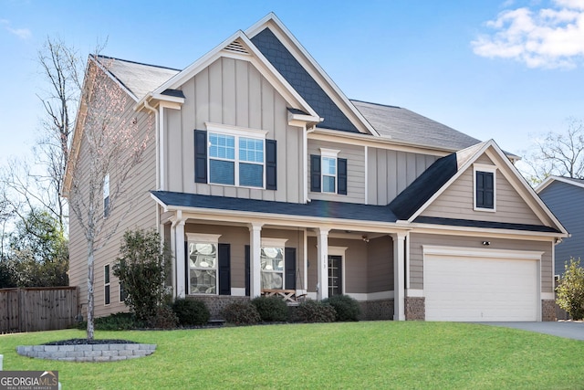craftsman-style home with a front lawn, board and batten siding, fence, and driveway