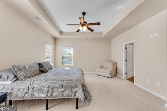 bedroom featuring carpet floors, baseboards, a raised ceiling, and visible vents