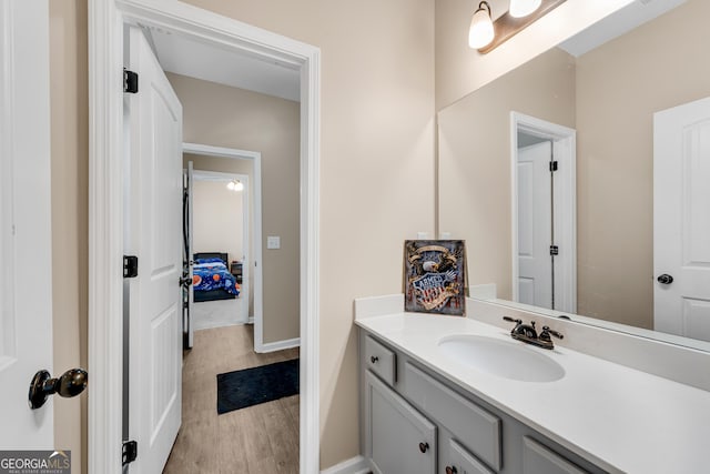 bathroom featuring baseboards, wood finished floors, and vanity
