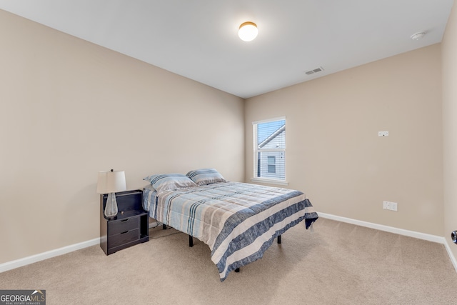 bedroom with baseboards, visible vents, and light carpet