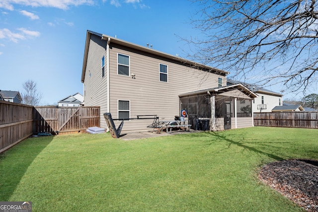 back of house with a fenced backyard, a lawn, a patio, and a sunroom
