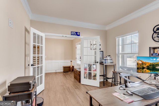 home office with a wainscoted wall, ornamental molding, french doors, and wood finished floors