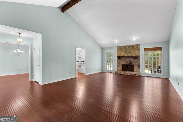 unfurnished living room featuring wood-type flooring, a notable chandelier, beam ceiling, and plenty of natural light