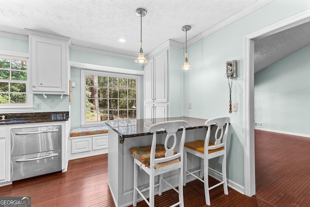 kitchen with white cabinets, a warming drawer, and a healthy amount of sunlight