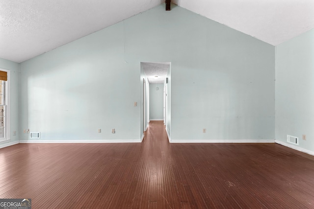 empty room with visible vents, baseboards, high vaulted ceiling, and wood finished floors