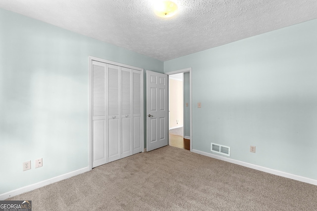 unfurnished bedroom with visible vents, baseboards, carpet, and a closet