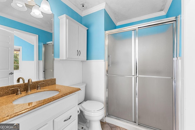 bathroom featuring vanity, a shower stall, toilet, and ornamental molding