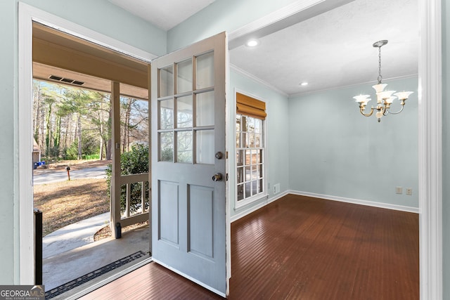 entrance foyer featuring baseboards, a healthy amount of sunlight, dark wood-style flooring, and a chandelier