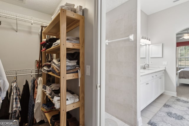 246 Heron Ct, Saint Marys, GA 31558 - interior space with vanity, a textured ceiling, a tile shower, and ceiling fan