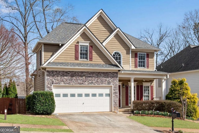 view of front facade with stone siding, roof with shingles, concrete driveway, and fence