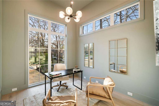 home office featuring an inviting chandelier, wood finished floors, and baseboards