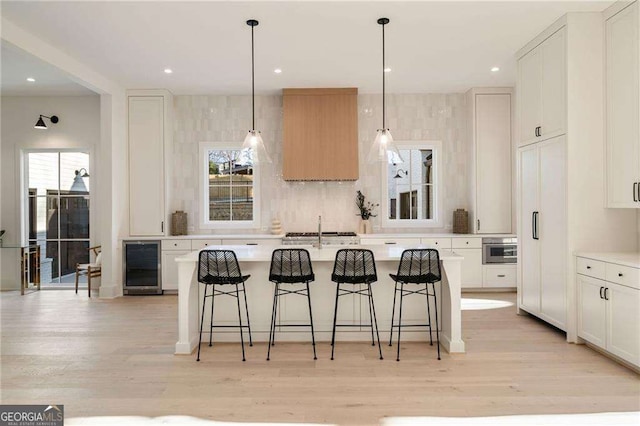 kitchen featuring light countertops, beverage cooler, and a wealth of natural light