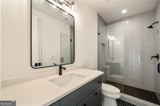 bathroom featuring a stall shower, toilet, and vanity