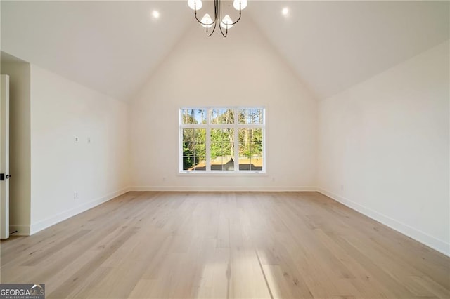 additional living space with high vaulted ceiling, baseboards, light wood finished floors, and a chandelier