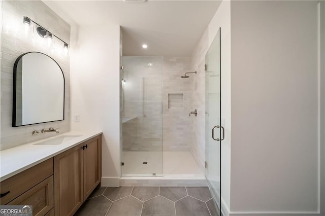 full bathroom featuring tile patterned floors, a shower stall, vanity, and baseboards