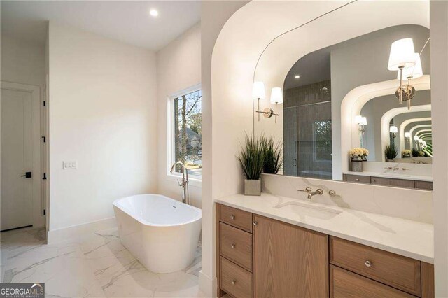 bathroom with tiled shower, a freestanding bath, marble finish floor, and vanity